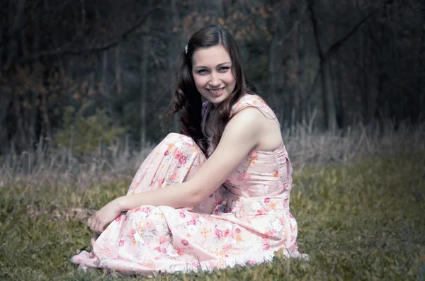 Smiling girl who is sitting on the grass — Stock Photo, Image