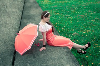 şemsiye ile neşeli kız bir betonarme döşeme üzerine bir adam oturuyor