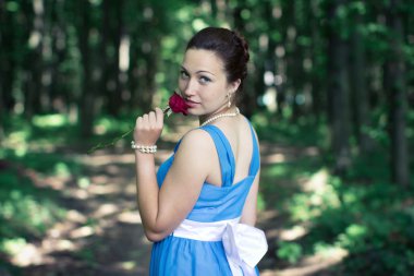 kız ile kırmızı gül karanlık ormanın içinde onun elinde arkasını döner