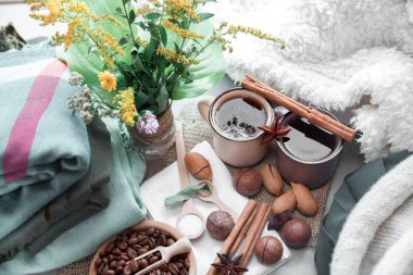 Battaniyenin üzerinde fındık ve tarçınlı iki fincan kahve.