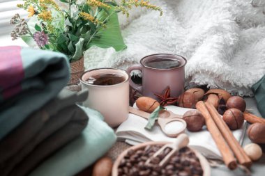 Battaniyenin üzerinde fındık ve tarçınlı iki fincan kahve.