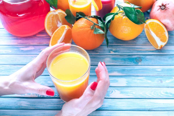 Φρεσκοστυμμένο Χυμό Πορτοκαλιού Γυναικεία Χέρια Πορτοκάλια Και Φρούτα Ροδιού Μπλε — Φωτογραφία Αρχείου