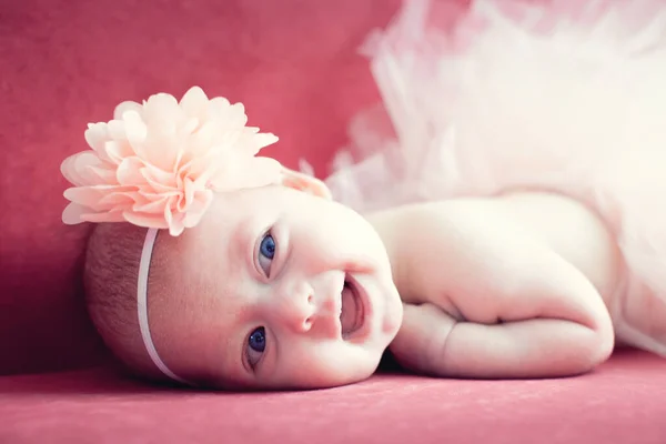 Uśmiechnięta Nowonarodzona Dziewczynka Kwiatem Włosach Czerwonej Kanapie — Zdjęcie stockowe