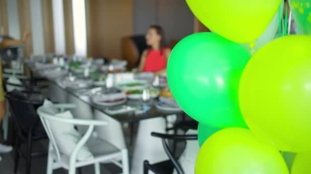 Green balloon decorations indoors during child birthday party — Stock Video