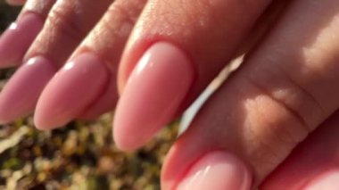Oldukça yeni yapılmış pembe jel tırnak manikürü. Yakın görüş.