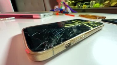Bozuk ekranlı bozuk modern telefon ve arka planda oynayan çocuk