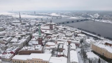 Yaşlı Riga karla kaplı, arkasında Daugava nehri var.