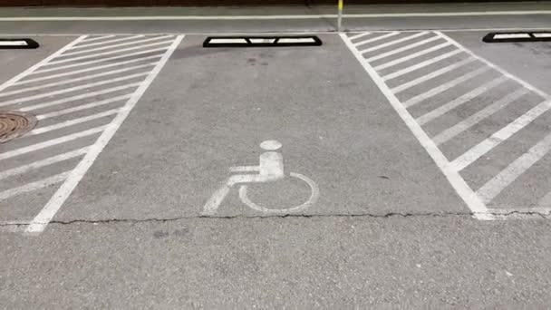 Pan up: Disabled sign at mall parking lot at night — Stock Video