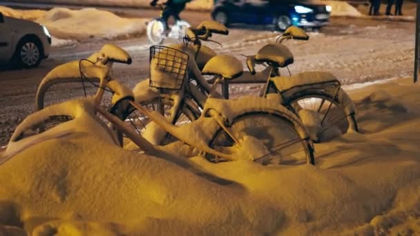Велосипеды, покрытые снегом после сильного шторма или метели в центре города — стоковое видео