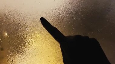 Yeni yıl arifesinde ıslak pencerede 2022 yazan kadınların pov görüntüsü