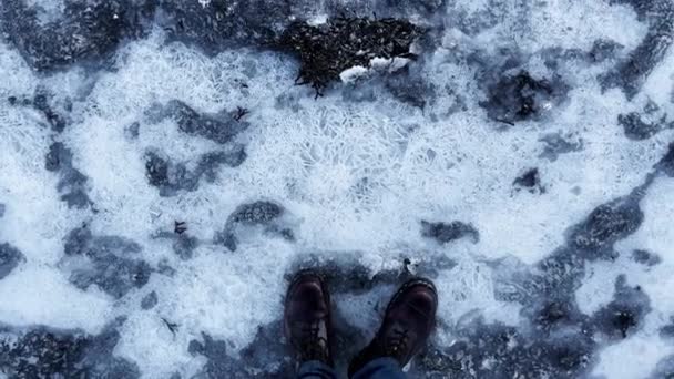 Ο άνθρωπος με μπότες πατάει στον πάγο και το κάνει να ραγίζει στην παγωμένη λίμνη — Αρχείο Βίντεο