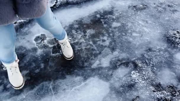 Jovem mulher de botas brancas brincando com gelo pisando e tornando-o crack — Vídeo de Stock