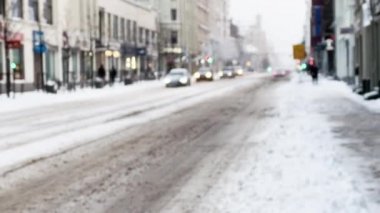 Odaklanamayan: Şehir, kar yağışları sırasında arabaların ve insanların yanından geçmesiyle meşgul