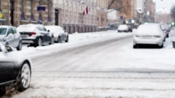 Vista borrosa sobre la ciudad nevada durante las nevadas con los coches que pasan — Vídeos de Stock