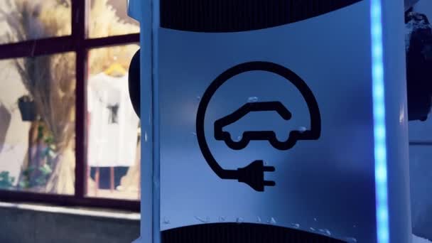 Visa över blå elbil laddare mot galleria skyltfönster — Stockvideo