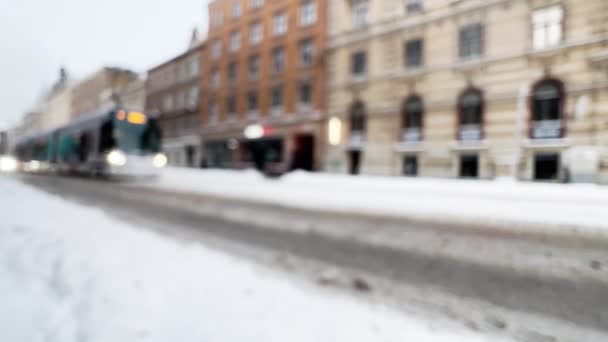 Gran tranvía borroso en el centro de la ciudad de invierno durante el mal tiempo y las nevadas — Vídeos de Stock