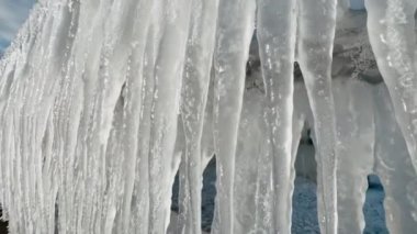 Metal parmaklıklardan sarkan buz saçakları eriyor.