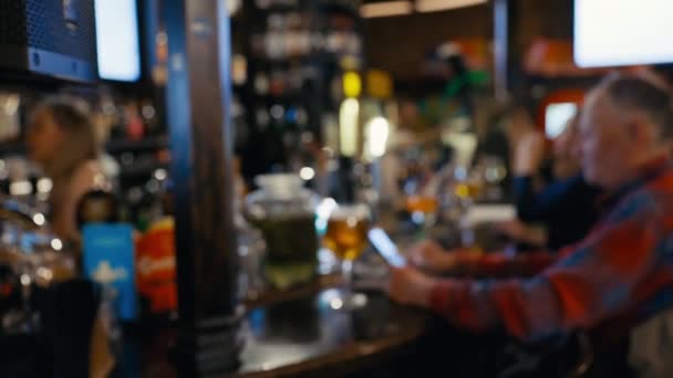 Niewyraźny widok starszego mężczyzny korzystającego ze smartfona w barze lub pubie w nocy — Wideo stockowe
