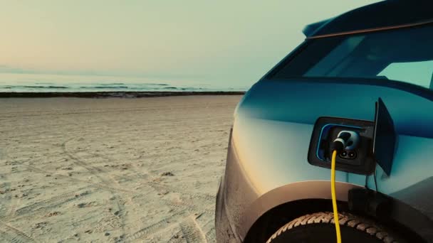 Электромобиль заряжается на зарядной станции E-vehicle на пляже — стоковое видео