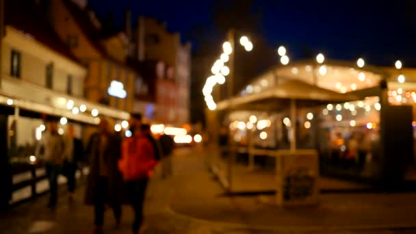 BLURRY: Många människor på natten promenader nära öppen restaurang terrass — Stockvideo