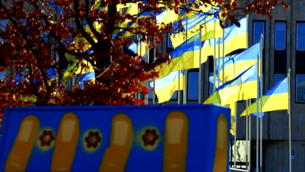 Ηλιόλουστη μέρα και φτερουγίζοντας ουκρανικές σημαίες στην ευρωπαϊκή πόλη — Αρχείο Βίντεο