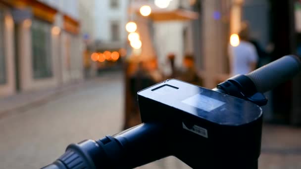 Vue rapprochée du scooter électrique poignée contre le centre-ville de nuit — Video
