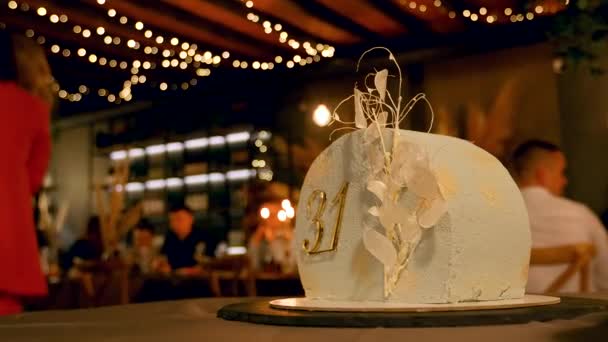 Дуже стильний і смачний день народження торт з багатьма людьми на задньому плані — стокове відео