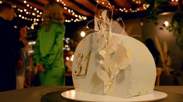 Люди у фоновому режимі дивляться на торт на день народження на вечірці — стокове відео