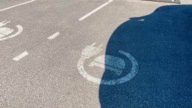 Alışveriş merkezinin yanındaki otoparkta elektrikli araba şarj istasyonu tabelası.