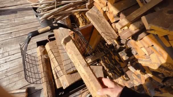 POV: Mužská ruka dává nasekané dřevo do přenosné krabice v ukrajinské vesnici — Stock video