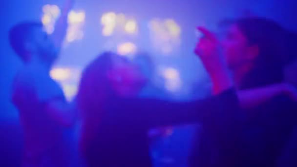 Sfocato e sfocato: Giovani e simpatici frequentatori di feste che ballano in un nightclub — Video Stock