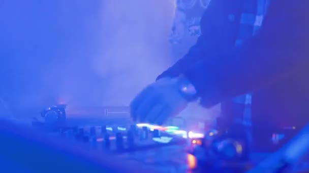 Two DJs playing and mixing in vivid nightclub illumination — Stockvideo