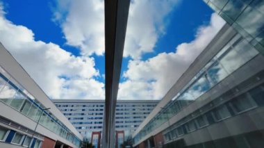 Hızlı hareket eden bulutlara karşı modern bir merkez hastane binasının yansıması.