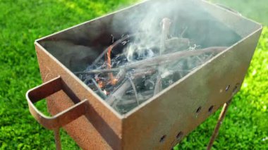 Kuruluş çekimi: Kır evinin arka planında ızgarada yanan odun sırasında çok fazla duman ve alev gerçek zamanlı