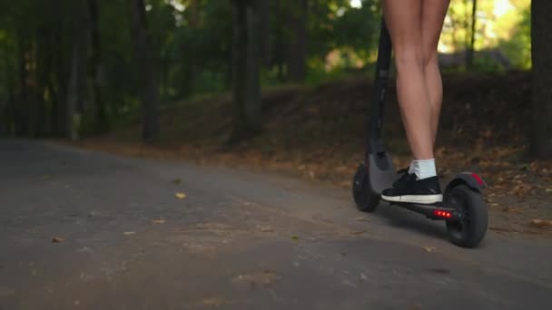Camera Follows Young Woman Riding Electric Scooter Naked Legs Wearing — Stock video