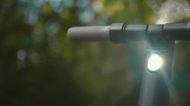 Dreamy close view of an electric scooter handle bars with bright light