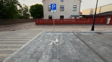 Small town disabled parking lot white sign over brick pavement real time