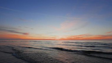 Amazing sunset at sea with waves and sun already not visible slow motion