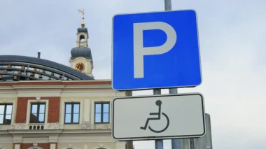 Establishing shot: Old disabled sign on a pole at an old town in Europe real time