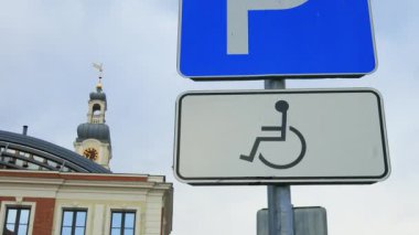 Close view: Disabled parking sign on a pole at an old town in Europe real time
