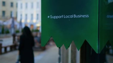 Support Local Business sign in a modern city at night real time