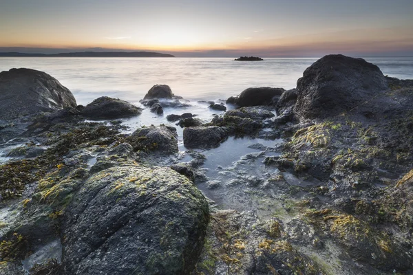 Irish rocky shore at sunrise with colorful sky — Stock Photo, Image