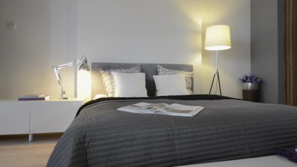 Schlafzimmereinrichtung mit grauem Bett und weißen Wänden — Stockvideo