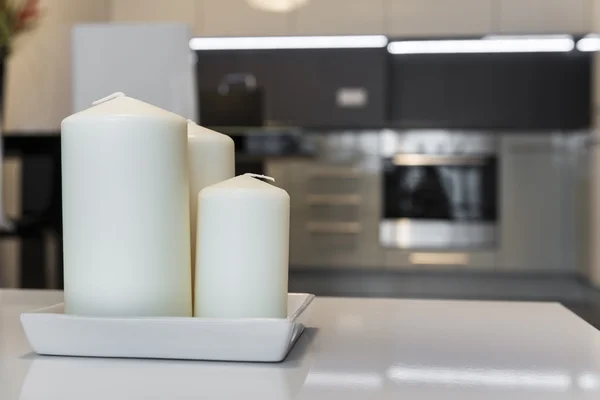 Three candles with defocus kitchen in background — Stock Photo, Image