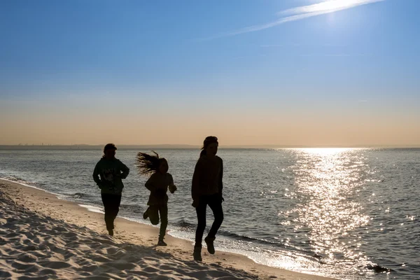 Silhouette junger Menschen am Strand — Stockfoto