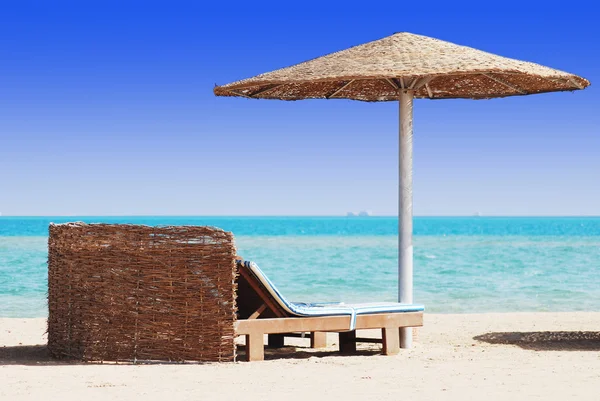Boş plaj sandalye ile denizde saman tente — Stok fotoğraf