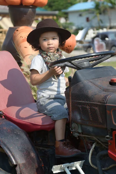 Happy little boy of two years having fun on tractor in summer — Stock Photo, Image