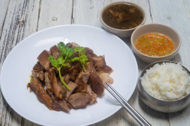 Çin bitkileriyle haşlanmış domuz budu. Tayland usulü sirkeli biber turşusuyla servis edilir..