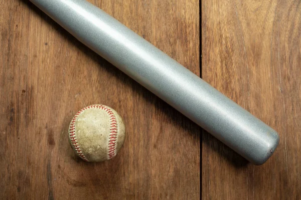 baseball ball and baseball bat isolated on wooden background.
