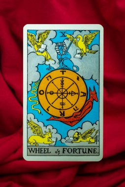 Çarkıfelek Tarot Sürücü Kartı Kırmızı kumaş arka planda bekleme güvertesi